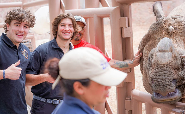 Two adults smiling with rhino